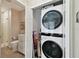 Bright, small bathroom with toilet, vanity, and tiled shower and stacked washer/dryer combo in closet at 652 Ohio Pl, Sarasota, FL 34236