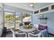 Relaxing screened porch with outdoor dining set, ceiling fan, and blue-painted wood paneled walls at 652 Ohio Pl, Sarasota, FL 34236