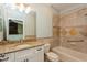 The bathroom has a large mirror, granite countertop and a tiled shower with tub at 7313 Gaberia Rd, Trinity, FL 34655