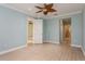 Bedroom with a wood look floor, a large ceiling fan and view into the main bathroom at 7313 Gaberia Rd, Trinity, FL 34655