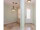 Foyer featuring decorative tile flooring, stylish light fixture, and a window with plantation shutters at 7313 Gaberia Rd, Trinity, FL 34655