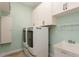 Bright laundry room features modern washer and dryer, cabinet storage, and a utility sink at 7313 Gaberia Rd, Trinity, FL 34655
