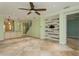 Open floor plan living room featuring travertine tile floor, accent wall and stair case to the upper level at 7313 Gaberia Rd, Trinity, FL 34655