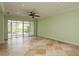 Spacious living room featuring travertine tile floor, large sliding glass doors and neutral paint color at 7313 Gaberia Rd, Trinity, FL 34655