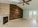 Bright living room with wood accent wall, fireplace, ceiling fan, and french doors at 7313 Gaberia Rd, Trinity, FL 34655