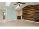 Living room featuring wood wall accent, fireplace, ceiling fan, and skylights at 7313 Gaberia Rd, Trinity, FL 34655