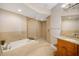 Bright bathroom featuring a soaking tub, separate glass-enclosed shower, and a vanity with granite countertop at 1026 Bellasol Way # 4403, Apollo Beach, FL 33572