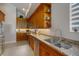 Traditional kitchen with wooden cabinets, granite countertops, stainless steel appliances, and tiled flooring at 1026 Bellasol Way # 4403, Apollo Beach, FL 33572