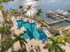 Aerial view of a community pool surrounded by lounge chairs, landscaping and boat docks along the bay at 1026 Bellasol Way # 4403, Apollo Beach, FL 33572