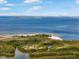 Expansive aerial view of a waterfront and beach with lush green foliage and distant skyline at 1026 Bellasol Way # 4403, Apollo Beach, FL 33572