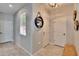 Bright entryway with neutral tones, featuring tile floors, and a round decorative shelf at 10421 Laguna Plains Dr, Riverview, FL 33578