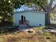 Exterior back of a light-blue home, features a small wood porch and stone patio at 112 E Emily St, Tampa, FL 33603