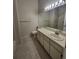 Bathroom featuring a single sink vanity, large mirror, and a shower/tub combo at 11638 Hidden Hollow Cir, Tampa, FL 33635