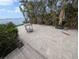 View of outdoor patio area with stone pavers, ocean views, and lush tropical landscaping at 11697 Grove St, Seminole, FL 33772