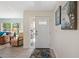 Bright foyer with a front door view, wood-look tile flooring, and adjacent comfortable living spaces at 1303 Glengarry Dr, Palm Harbor, FL 34684