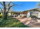 Charming home featuring a brick driveway and walkway leading to the covered entryway, with shade trees and a 1-car garage at 13225 108Th Ave, Largo, FL 33774