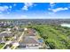 Expansive aerial view of a home with a screened pool in a lush, landscaped neighborhood near a lake at 13235 Graham Yarden Dr, Riverview, FL 33579