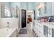 Well-lit bathroom with double sinks, walk-in shower, soaking tub, and access to main bedroom at 13235 Graham Yarden Dr, Riverview, FL 33579
