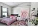 Cozy bedroom with a comfortable bed, a window, and creative pink accents throughout the room at 13235 Graham Yarden Dr, Riverview, FL 33579