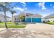 Charming single-Gathering home featuring a three-car garage and eye-catching turquoise doors at 13235 Graham Yarden Dr, Riverview, FL 33579