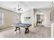 Open-concept living room featuring hardwood floors, high ceilings, and a stylish billiard table at 13235 Graham Yarden Dr, Riverview, FL 33579