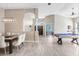 Open-concept living room featuring hardwood floors, high ceilings, and a stylish billiard table at 13235 Graham Yarden Dr, Riverview, FL 33579