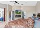 Main bedroom with wall-mounted tv, ceiling fan, and access to ensuite bathroom at 13235 Graham Yarden Dr, Riverview, FL 33579