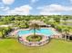 Community pool area with mature palm trees, lounge chairs, umbrellas and a covered pavilion at 13235 Graham Yarden Dr, Riverview, FL 33579