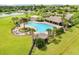 Community pool with palm trees, a covered pavilion and a neighboring lake at 13235 Graham Yarden Dr, Riverview, FL 33579