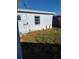 Back of home with overgrown yard and a few cacti at 14034 Marguerite Dr, Madeira Beach, FL 33708