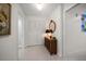 Hallway with decorative cabinet, closet, and easy access to bathroom at 14484 Neptune Rd, Seminole, FL 33776