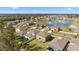 Aerial view of neighborhood homes with small pond and green space at 1454 Tahitian Sunrise Dr, Plant City, FL 33565