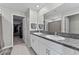 Bathroom featuring dual sinks, granite countertops, white cabinets, and an open doorway to a walk-in closet at 1454 Tahitian Sunrise Dr, Plant City, FL 33565