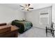 This bedroom features a dark bed, dark ceiling fan, dresser, and a window with blinds at 1454 Tahitian Sunrise Dr, Plant City, FL 33565