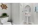 Charming powder room features a pedestal sink, toilet, ship's wheel, and neutral decor at 1454 Tahitian Sunrise Dr, Plant City, FL 33565