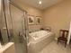 Bathroom showcasing a tub, shower, and neutral tile at 15 Jefferson S Ct, St Petersburg, FL 33711
