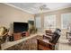 Comfortable living room with tile flooring, ceiling fan, and a large television at 15 Jefferson S Ct, St Petersburg, FL 33711