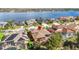 An aerial view of the home by a lake showcases the screened-in pool and neighborhood at 16410 Ivy Lake Dr, Odessa, FL 33556