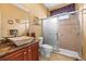 Bathroom featuring granite countertops, a vessel sink, and a tiled shower with glass doors at 16410 Ivy Lake Dr, Odessa, FL 33556