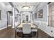 Elegant dining room with a long table, upholstered chairs, mirrored wall, and stylish lighting fixtures at 16410 Ivy Lake Dr, Odessa, FL 33556
