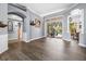 Open-concept living space with hardwood floors, arched doorways, and a large sliding door leading to outdoor pool area at 16410 Ivy Lake Dr, Odessa, FL 33556