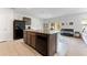Kitchen island featuring a granite counter top, stainless steel sink, and dark wood cabinets at 16549 Secret Meadow Dr, Odessa, FL 33556