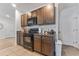 Kitchen with dark cabinetry, granite countertops, black appliances, and view into the hall at 16549 Secret Meadow Dr, Odessa, FL 33556