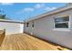 Exterior view of the home with a wood deck, back windows and access doors at 1940 N Betty Ln, Clearwater, FL 33755