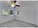 Bedroom with ceiling fan, light gray flooring and two windows providing ample natural light at 1940 N Betty Ln, Clearwater, FL 33755