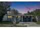 Charming single-story home featuring a carport, well-maintained lawn, and inviting front porch under a colorful sky at 1940 N Betty Ln, Clearwater, FL 33755