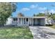 Charming single-story home featuring a covered porch and a driveway, set against a blue sky at 1940 N Betty Ln, Clearwater, FL 33755
