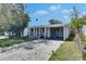 Single story home featuring a covered porch and a driveway, surrounded by a well-maintained lawn at 1940 N Betty Ln, Clearwater, FL 33755