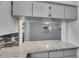 Kitchen with granite countertops and tile backsplash open to the living room at 1940 N Betty Ln, Clearwater, FL 33755