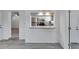 View of kitchen with stainless appliances from the adjacent living area with gray floors at 1940 N Betty Ln, Clearwater, FL 33755